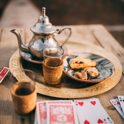 Authentic Moroccan tea setup with playing cards on a rustic wooden table in Marrakesh.
