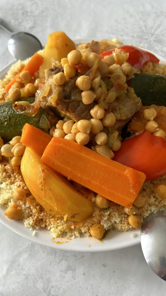 A vibrant dish of Moroccan couscous served with vegetables, chickpeas, and meat.